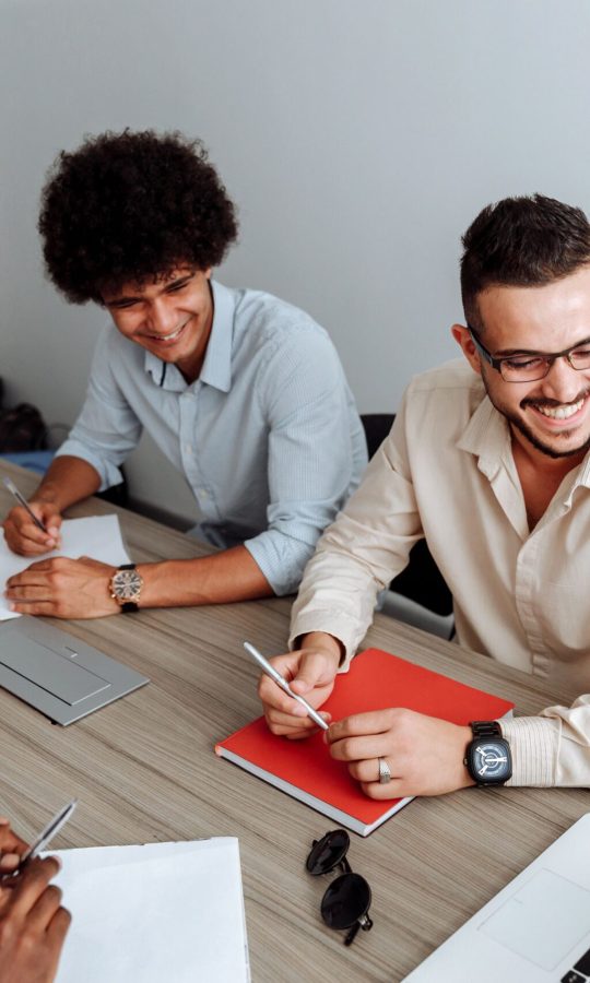 A group of diverse professionals collaborating during a team meeting in a modern office setting.